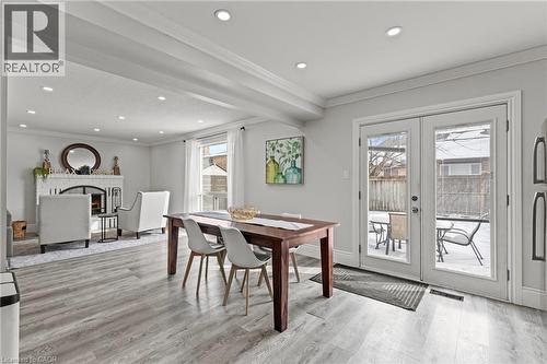 Open-concept living area with light wood-finish flooring, recessed lighting, white trim, and a white brick fireplace - 27 Barbara Court, Hamilton, ON - Indoor Photo Showing Other Room