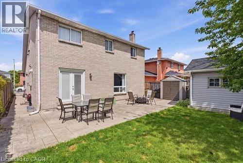 Expansive patio area featuring a brick exterior, double glass doors, a storage shed, and a detached structure - 27 Barbara Court, Hamilton, ON - Outdoor With Deck Patio Veranda With Exterior