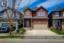 Brick facade residence featuring a covered front entry, an attached garage, a paved driveway, and mature landscaping - 40 Fairgrounds Drive, Binbrook, ON  - Outdoor With Facade 
