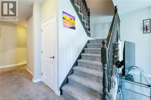Carpeted staircase featuring a dark wood newel post and balusters - 40 Fairgrounds Drive, Binbrook, ON - Indoor Photo Showing Other Room
