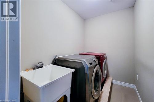 Dedicated utility room featuring a large wash basin with chrome faucet and tile flooring - 40 Fairgrounds Drive, Binbrook, ON - Indoor Photo Showing Laundry Room