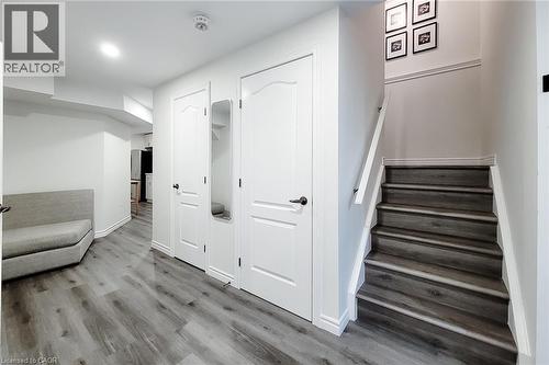 Staircase featuring wood-finish treads and risers, white handrail, and trim - 40 Fairgrounds Drive, Binbrook, ON - Indoor Photo Showing Other Room