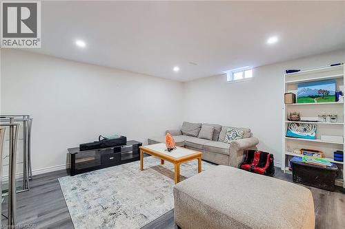 Finished basement room featuring recessed lighting, wood-finish flooring, a built-in shelving unit, and a window for natural illumination - 40 Fairgrounds Drive, Binbrook, ON - Indoor Photo Showing Basement