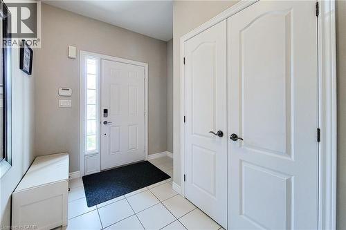 Entryway featuring white paneled doors, sidelight window, and tile flooring - 40 Fairgrounds Drive, Binbrook, ON - Indoor Photo Showing Other Room
