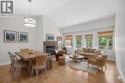 Living/dining room with vaulted ceilings & a gas fireplace **virtually staged** - 