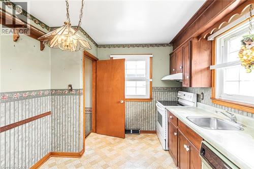 Kitchen featuring wood cabinetry, laminate countertops, and resilient vinyl flooring - 435 East 36Th Street, Hamilton, ON - Indoor Photo Showing Kitchen