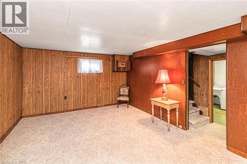 Wood-paneled room featuring patterned carpeting, a window with curtains, and a drop ceiling - 435 East 36Th Street, Hamilton, ON - Indoor