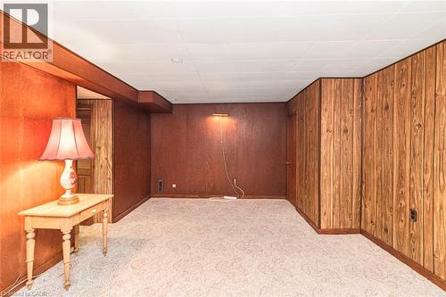 Carpeted room featuring wood paneling on walls, a drop ceiling, and an architectural beam - 435 East 36Th Street, Hamilton, ON - Indoor Photo Showing Other Room