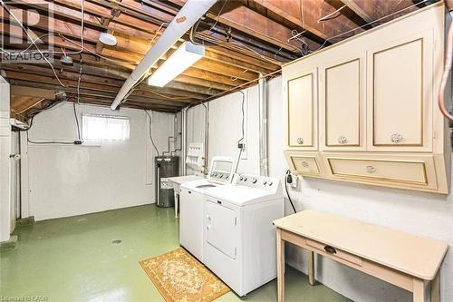 Dedicated laundry area featuring white appliances, wall-mounted cabinetry, and exposed ceiling joists - 435 East 36Th Street, Hamilton, ON - Indoor Photo Showing Laundry Room