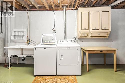 Laundry area featuring a double utility sink, washer and dryer, and exposed ceiling joists - 435 East 36Th Street, Hamilton, ON - Indoor Photo Showing Laundry Room