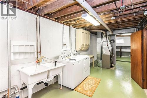 Utility space featuring a double basin sink, exposed ceiling joists, and painted concrete flooring - 435 East 36Th Street, Hamilton, ON - Indoor Photo Showing Laundry Room