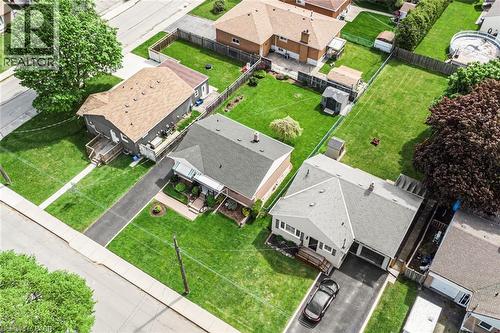 Residential property featuring a grey exterior, attached garage, and a long asphalt driveway - 435 East 36Th Street, Hamilton, ON - Outdoor With View