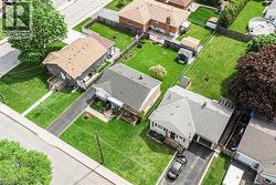 Residential property featuring a grey exterior, attached garage, and a long asphalt driveway - 