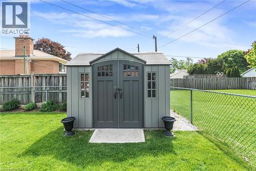Freestanding storage shed featuring double doors with window panes, side windows, and a shingled roof - 435 East 36Th Street, Hamilton, ON - Outdoor