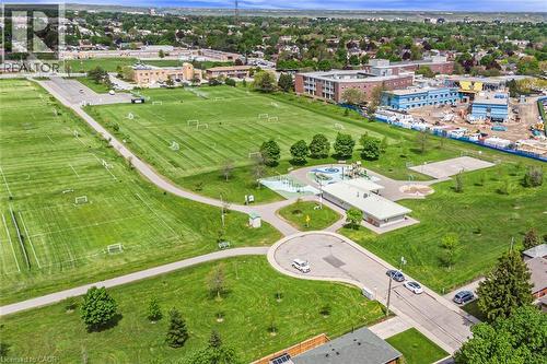Expansive green spaces featuring multiple sports fields, paved walking paths, and a dedicated playground area - 435 East 36Th Street, Hamilton, ON - Outdoor With View