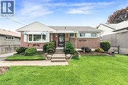 Red brick exterior with white trim and a gabled accent - 