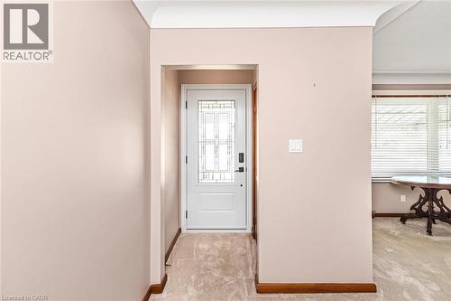 Entryway featuring a white door with decorative glass inserts, light neutral wall paint, and crown molding - 435 East 36Th Street, Hamilton, ON - Indoor Photo Showing Other Room