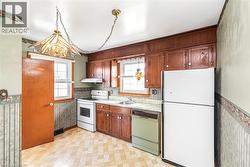 Kitchen featuring wood cabinetry, a built-in range hood, and two windows - 