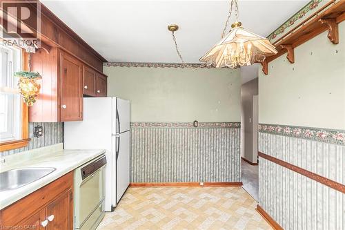 Kitchen with wood-finish cabinetry, a stainless steel sink, and a light-colored countertop - 435 East 36Th Street, Hamilton, ON - Indoor Photo Showing Kitchen