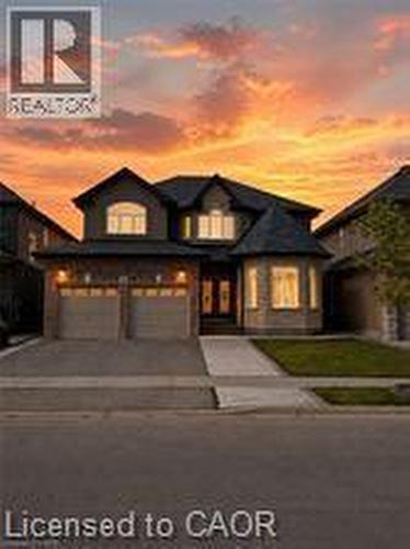 Stone and siding exterior featuring a double garage and concrete driveway - 85 Showcase Drive Unit# Main, Hamilton, ON - Outdoor With Facade