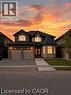 Stone and siding exterior featuring a double garage and concrete driveway - 85 Showcase Drive Unit# Main, Hamilton, ON  - Outdoor With Facade 