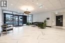 Lobby area featuring large format marble-look tile flooring, contemporary chandelier, full-height glass entrance, and decorative wainscoting - 1936 Rymal Road E Unit# 512, Hamilton, ON  - Indoor Photo Showing Other Room 
