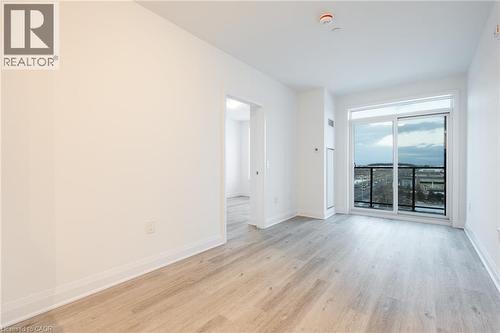 Bright interior space featuring a sliding glass door to a balcony with black railings - 1936 Rymal Road E Unit# 512, Hamilton, ON - Indoor Photo Showing Other Room