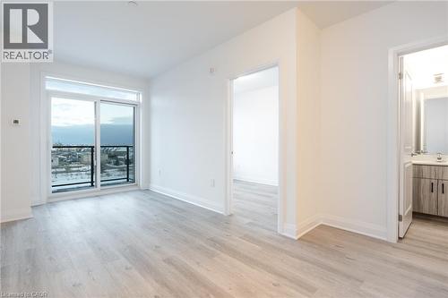Expansive sliding glass doors open to a balcony with black metal railings - 1936 Rymal Road E Unit# 512, Hamilton, ON - Indoor Photo Showing Other Room