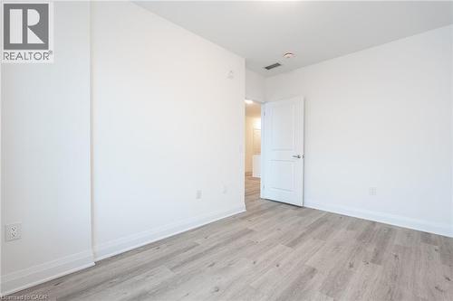 Spacious room featuring light wood-finish flooring and crisp white walls - 1936 Rymal Road E Unit# 512, Hamilton, ON - Indoor Photo Showing Other Room
