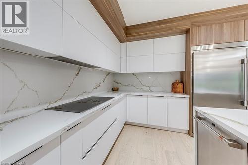 Modern kitchen featuring white flat-panel cabinetry and substantial countertops - 3937 Leonardo Street, Burlington, ON - Indoor Photo Showing Kitchen