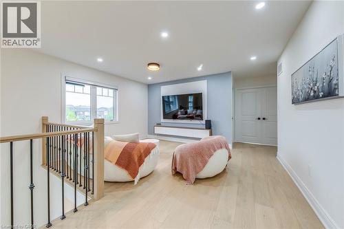 Open loft space featuring light wood-finish flooring, recessed lighting, and a modern window with exterior views - 3937 Leonardo Street, Burlington, ON - Indoor