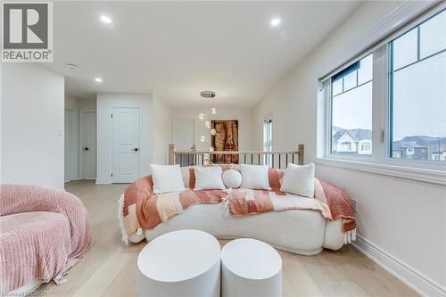 Upper-level landing featuring light wood-finish flooring, recessed lighting, white trim, and a large window with white framing - 3937 Leonardo Street, Burlington, ON - Indoor Photo Showing Dining Room