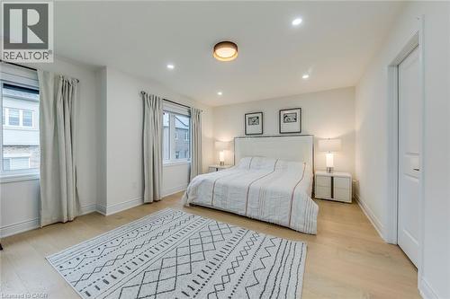 Bright bedroom with wood-finish flooring, recessed lighting, and a contemporary ceiling fixture - 3937 Leonardo Street, Burlington, ON - Indoor Photo Showing Bedroom