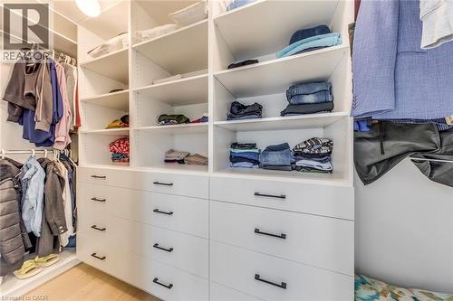 Custom closet system featuring multiple shelving units, drawers with matte black hardware, and hanging rods - 3937 Leonardo Street, Burlington, ON - Indoor With Storage