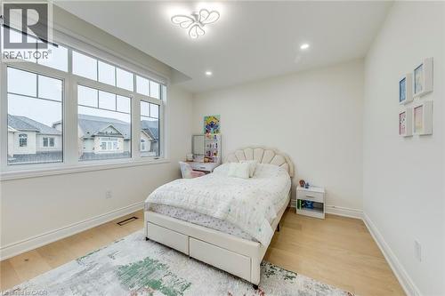 Bright room with large multi-pane windows, light wood-finish flooring, and crisp white walls - 3937 Leonardo Street, Burlington, ON - Indoor Photo Showing Bedroom