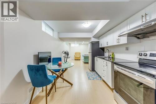 Kitchenette featuring white cabinetry, black countertops, stainless steel appliances, and a stainless steel sink with a gooseneck faucet - 3937 Leonardo Street, Burlington, ON - Indoor Photo Showing Kitchen