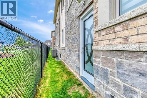 Exterior wall featuring mixed stone and brick cladding with a frosted glass door - 3937 Leonardo Street, Burlington, ON - Outdoor
