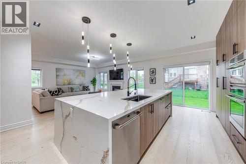 Expansive kitchen island with a waterfall countertop, integrated sink, and dishwasher - 3937 Leonardo Street, Burlington, ON - Indoor Photo Showing Kitchen With Upgraded Kitchen