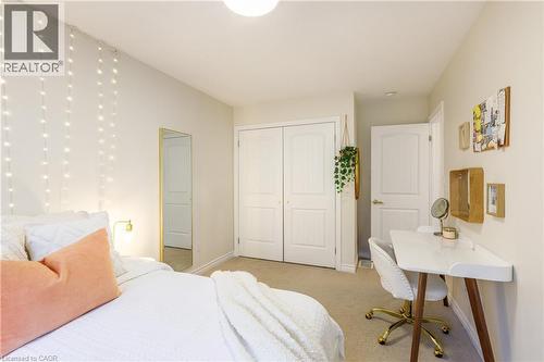 Bedroom featuring neutral wall paint, carpet flooring, a ceiling-mounted light fixture, and white bi-fold closet doors - 10 Redbud Crescent, Simcoe, ON - Indoor Photo Showing Bedroom