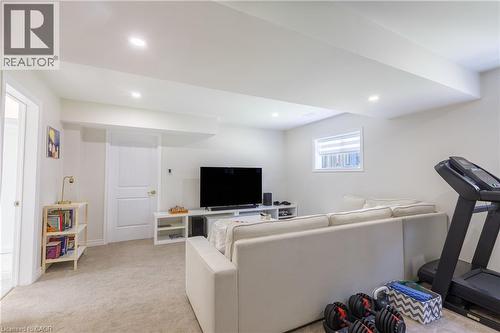Finished lower level featuring recessed lighting, plush carpet flooring, a window with horizontal blinds, and a built-in media console - 10 Redbud Crescent, Simcoe, ON - Indoor