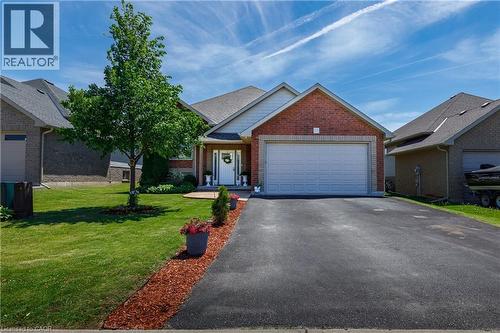 Brick facade residence with an attached two-car garage, asphalt driveway, and a manicured lawn - 10 Redbud Crescent, Simcoe, ON - Outdoor