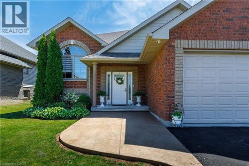 Brick exterior with a prominent arched window and a white paneled garage door - 10 Redbud Crescent, Simcoe, ON - Outdoor