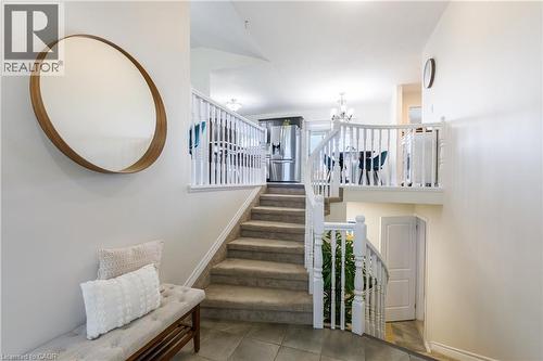 Split-level entry featuring a carpeted staircase with white balusters and handrails - 10 Redbud Crescent, Simcoe, ON - Indoor Photo Showing Other Room