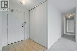 Entryway featuring a white paneled door, light-colored tile flooring, and a flush mount ceiling light - 