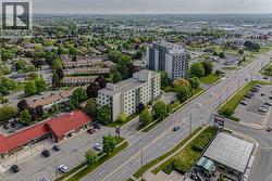 Aerial perspective showcasing multiple buildings, including multi-story residential structures and commercial properties, along a wide paved road - 