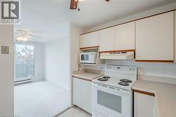Kitchen featuring white cabinetry with wood trim, a white electric range, and a built-in microwave - 