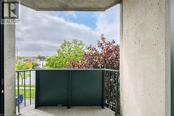 Private balcony featuring concrete walls, a dark metal railing, and a partial privacy screen - 
