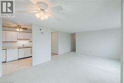 Expansive living area featuring light-toned carpeting and a ceiling fan with integrated lighting - 