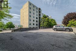Expansive paved parking area alongside a multi-story concrete building with multiple windows and balconies - 