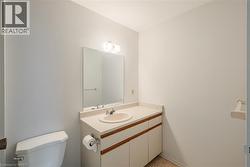 Bathroom featuring a vanity with integrated sink, wall-mounted mirror, and overhead lighting - 